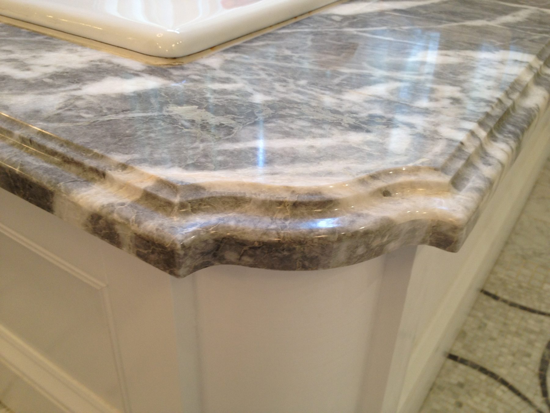 A hand-shaped, multi-tiered decorative edge on a natural stone counter, from a Leslie Guerci project